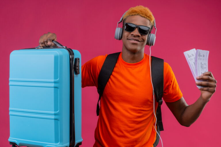 young-handsome-boy-with-backpack-headphones-holding-travel-suitcase (1) (1)